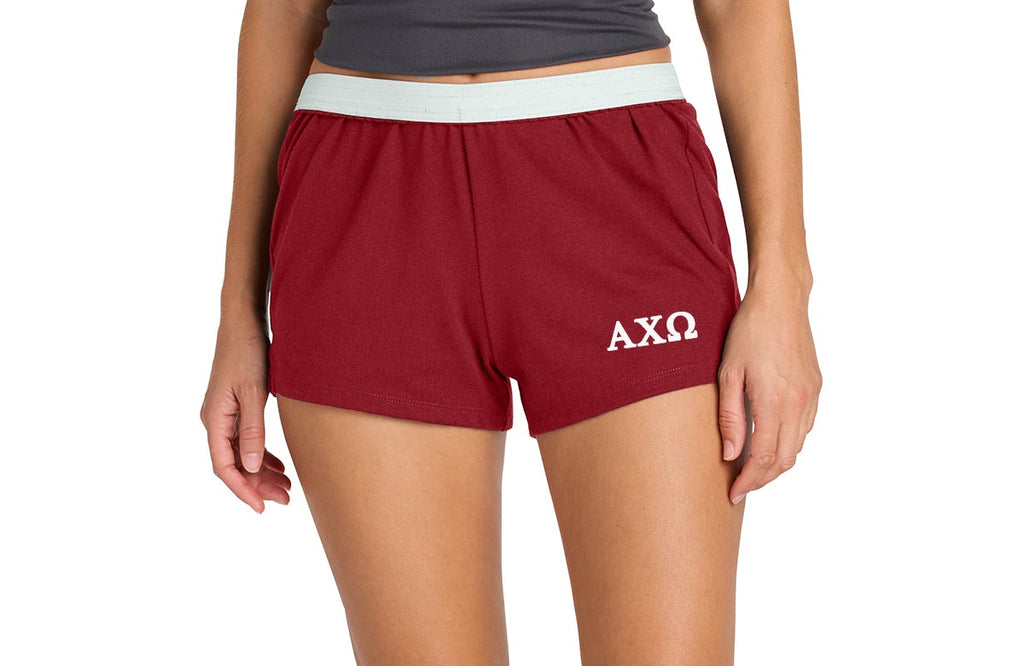 Person wearing red shorts with a logo on a white background