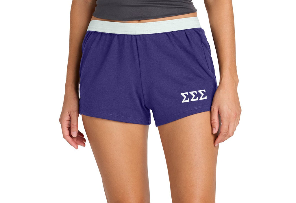 Person wearing purple shorts with a logo on a white background