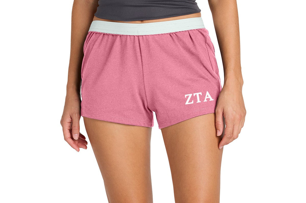 Person wearing pink shorts with 'ZTA' logo on a white background