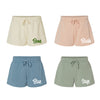 Four pairs of shorts in different colors with color names printed on them.